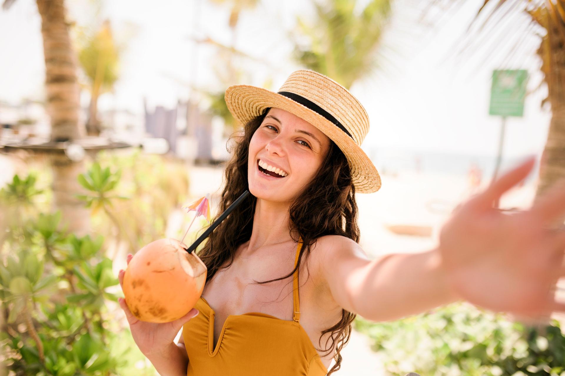 Self portrait of Woman with coconut drink relaxing at the beach